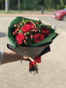 Elegancki bukiet z czerwonych róż i owoców hypericum