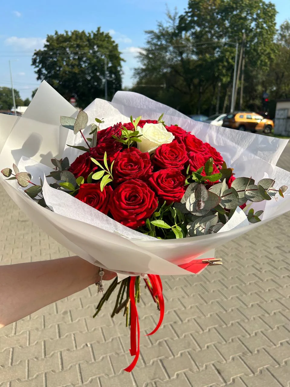 Bukiet czerwonych róż z jedną białą różą jako symbolem wyjątkowości