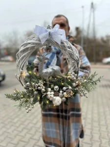 Zimowa dekoracja z jeleniem i srebrnymi bombkami – elegancki biały wieniec świąteczny
